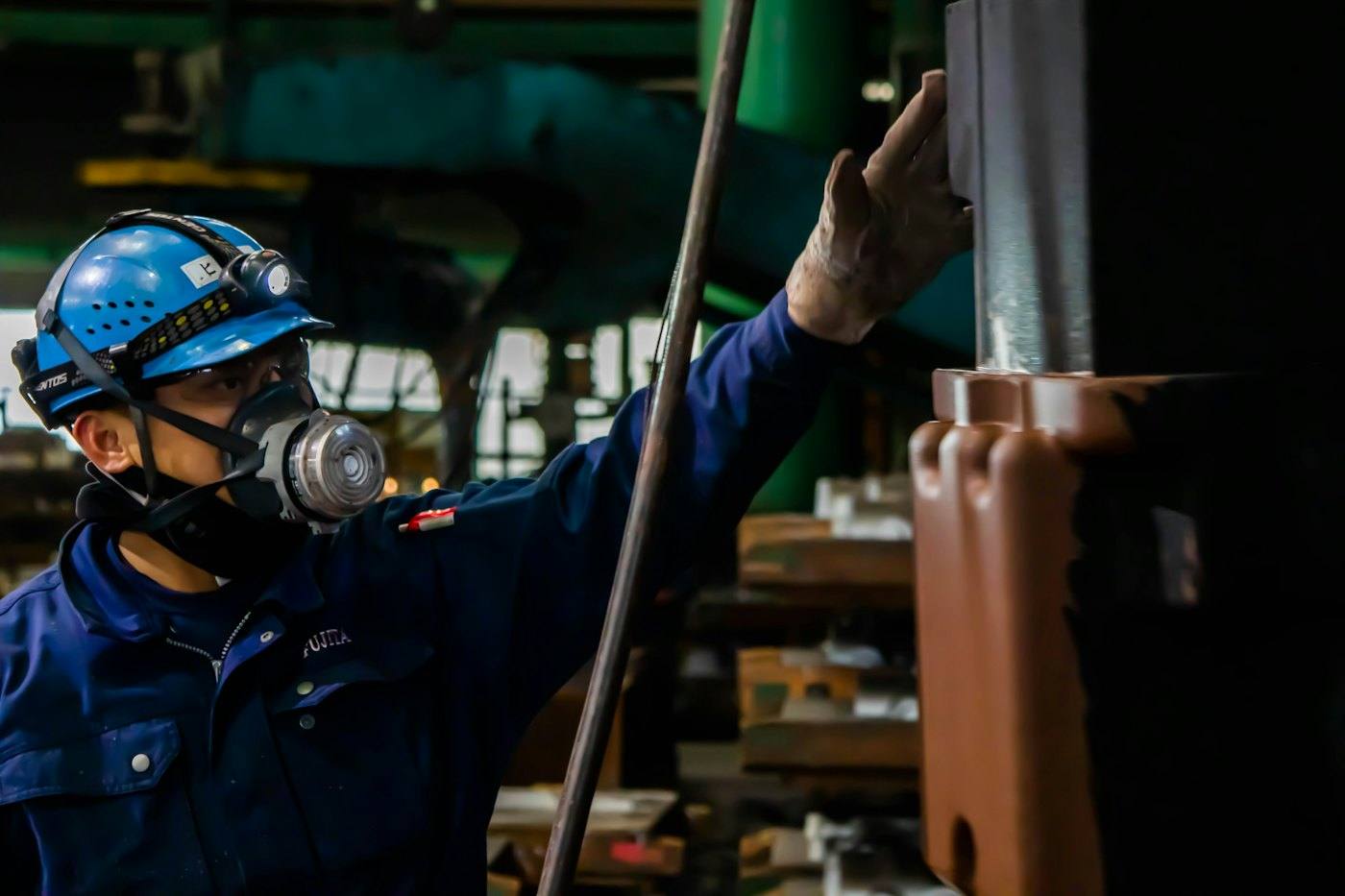 Technician wearing respiratory protection and hard hat